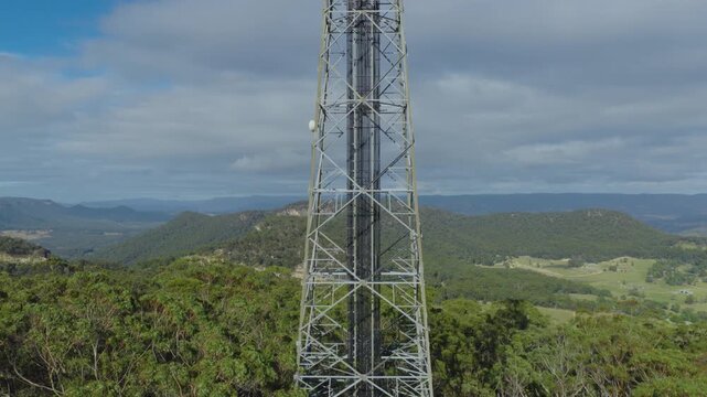 Aerial footage rising from the ground to the top of the steel framework structure and the antenna array technology on a large and high telecommunications tower in the Blue Mountains in NSW, Australia