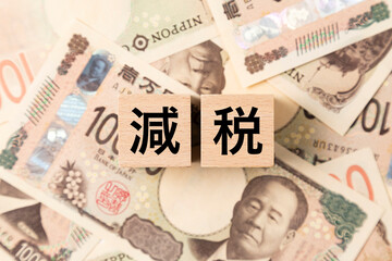 Fototapeta premium 「減税」と書かれたブロックとたくさんの一万円札 