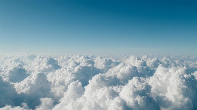 A stunning high-altitude perspective featuring a vast sea of fluffy white cumulus clouds stretching toward the horizon beneath a serene blue sky.