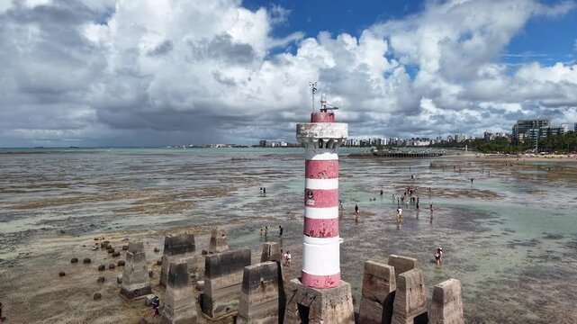 At low tide, the Ponta Verde Lighthouse reveals a unique landscape, surrounded by reefs and shallow waters that allow visitors to walk out into the sea in Macei&oacute;.- Alagoas, Brazil