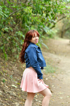 Mujer joven guatemalteca muy bella posando para la c&aacute;mara, vestida con una falda rosada y una chaqueta azul. Chica bonita rodeada de naturaleza.