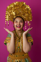 Naklejka premium Joyful Young Indonesian Asian Girl Wearing Ornate Gold Headdress and Traditional Costume for Cultural Celebration