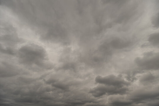 Dark skies with swirling winds. Overcast horizon precedes approaching storm gusts. Prestorm sky exhibits textured clouds with dynamic motion and contrasting shades of gray