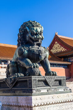 A male lion scrupture guarding the forbidden city in Beijing China with paws on a ball symbolic of power of the Chinese emperor