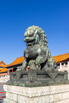 A female lion scrupture guarding the Forbidden City in Beijing China, with paws on a cub symbolizes continuous lineage of the Chinese emperor