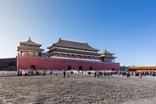 View of China Forbidden City South gate compound during sunrise with distant and blurry unrecognizable tourists crowd