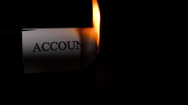 Word ACCOUNT on paper being burned with fire close-up on black background