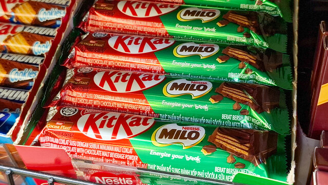 Row of KitKat Milo chocolate wafer bars in distinctive green packaging stacked on a retail store shelf on May 2, 2026 in Bangkok, Thailand