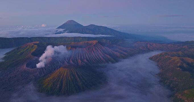 Scenic panorama of the Bromo Tengger Semeru National Park showcasing rugged terrain and atmospheric fog.