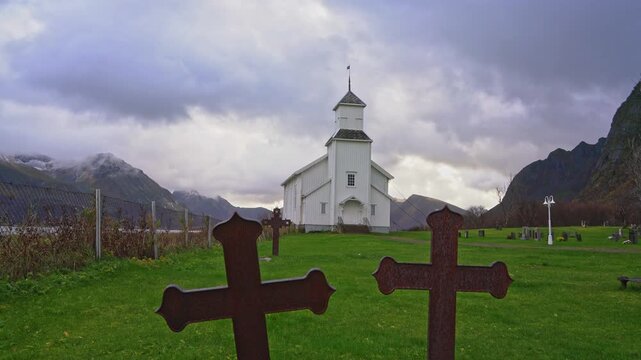 Gimsoy Church, Lofoten Islands, Norway: Breathtaking 4K Ultra HD Cinematic Stock Footage of the Iconic White Wooden Chapel, Featuring a Detailed Historic Tombstone and Grave in the Serene Foreground.
