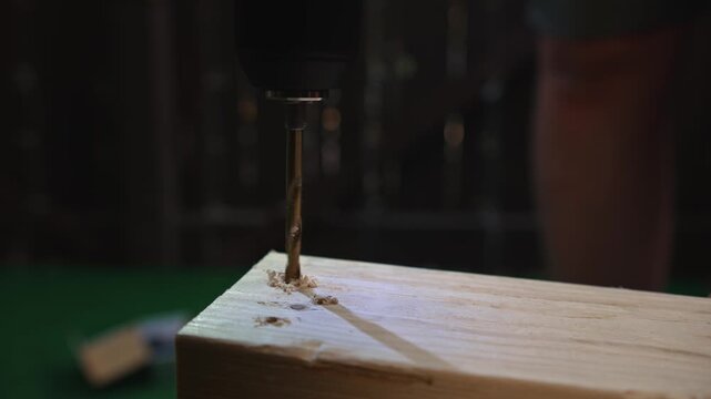 Drill bit making hole in wooden board close up creating process of precise material processing and carpentry and construction tasks