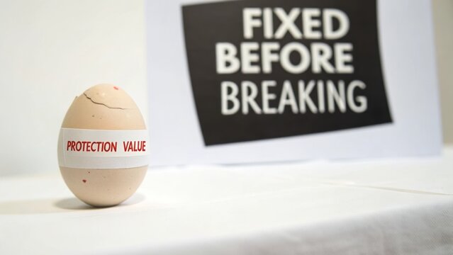 A Cracked Egg with a Label Reading "tion Value" and a Sign Saying "FIXED BEFORE BREAKING" Suggests a Concept of Repair and Prevention