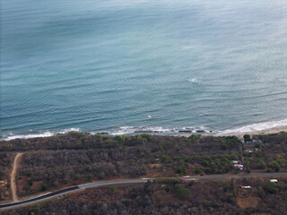 Fototapeta premium Coastline view from above near a road and water in daytime