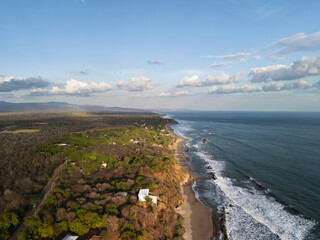 Fototapeta premium View of coastal landscape with waves and green land near beach