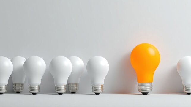 Row of seven unlit white bulbs with one glowing orange bulb, symbolizing innovation and uniqueness.
