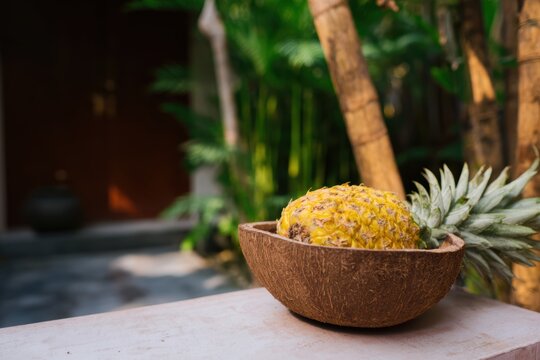 パイナップルはココナッツの殻で作られたボウルに置かれます