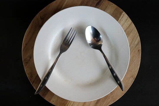 The position of the spoon and fork placed in an inverted V or triangle shape on the plate is a non-verbal signal in table manners which means you are taking a break or have not finished eating.