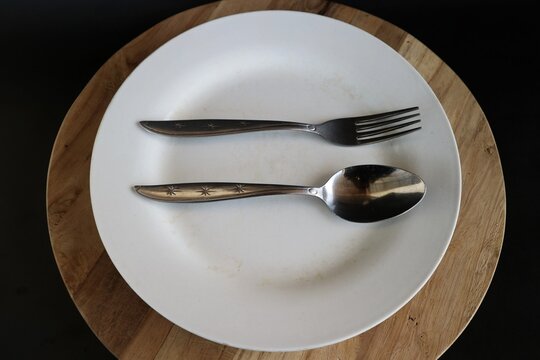 The position of the spoon and fork parallel and horizontal in the center of the plate is often interpreted as a signal that the food is delicious or filling.