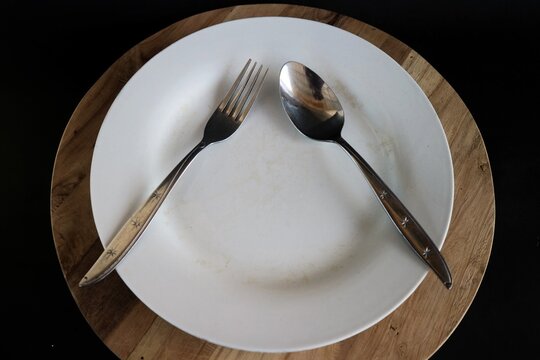 The position of the spoon and fork placed in an inverted V or triangle shape on the plate is a non-verbal signal in table manners which means you are taking a break or have not finished eating.