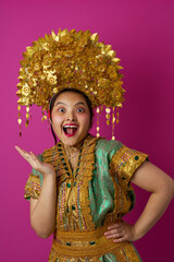 Naklejka premium Joyful Indonesian Asian Woman Wearing Elaborate Gold Headdress and Traditional Costume Celebrating Cultural Festival