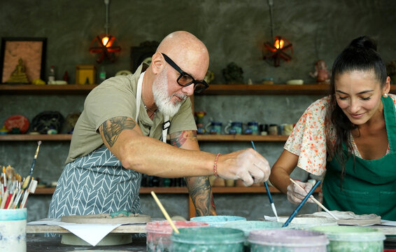 A happy couple makes ceramic plates in a workshop