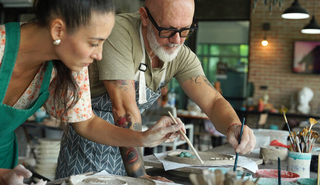 A happy couple makes ceramic plates in a workshop