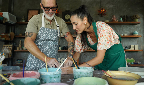 A happy couple makes ceramic plates in a workshop
