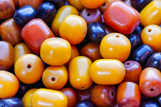 Close-Up of Polished Amber and Dark Resin Beads jewelry making or traditional crafts.