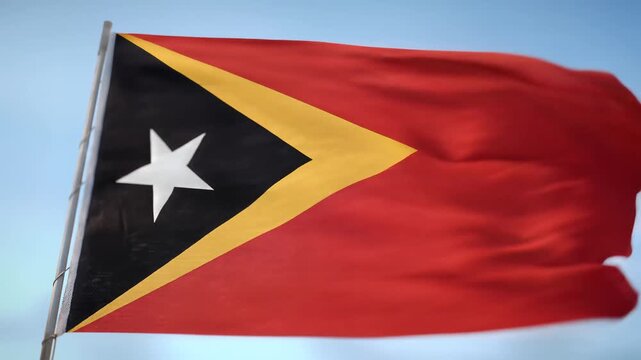 Timor Leste Flag Waving in the Wind Against a Clear Blue Sky.