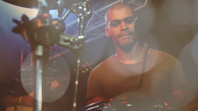 Drummer playing music for stage gig after spotlights hitting stage, animated bokeh lighting drums