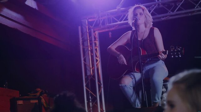 Overlay rotating and fading, exposing singer playing guitar on music stage, shifting audience focus