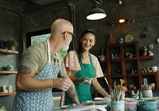 A happy couple makes ceramic plates in a workshop