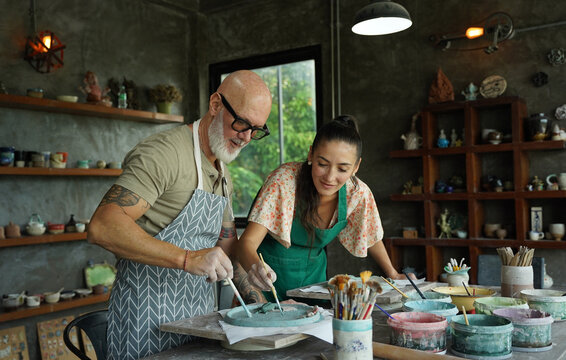 A happy couple makes ceramic plates in a workshop