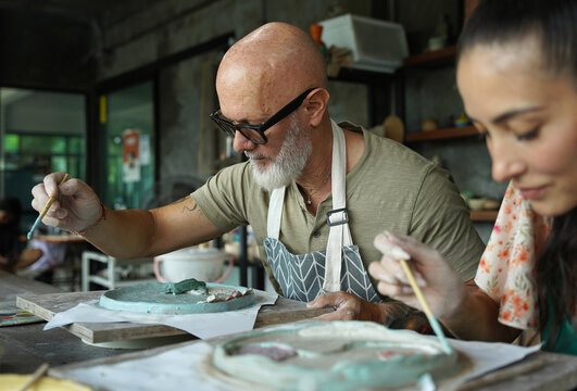 A happy couple makes ceramic plates in a workshop