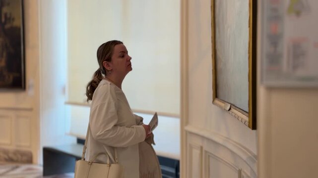 Refined lady examining ornate art piece in peaceful gallery setting