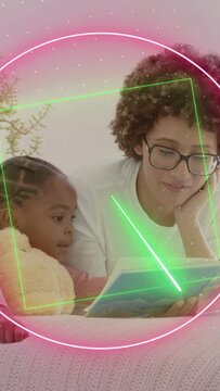 Vertical video: Mom opening book and reading for study, kid holding toy neon rings moving across