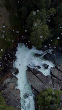 Vertical video: Drone taking off, camera tracking narrow rapid, droplets rising, mapping channel