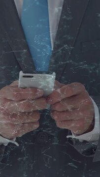 Vertical video: Suit torso holding white phone after brief pause making thumb taps to navigate apps