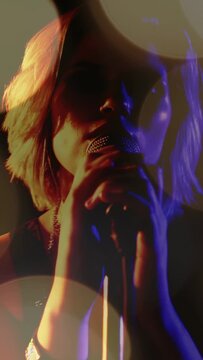 Vertical video: Singer reaching mic cupping grille singing for music while bands and bokeh glowing