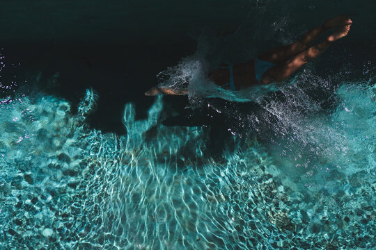 Aerial view of woman swimming with splash in villa pool, Uluwatu, Bali