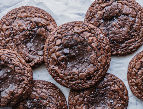 Close up of freshly baked chocolate brownie cookies on parchment.