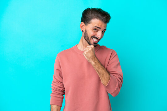 Young caucasian man isolated on blue background celebrating a victory