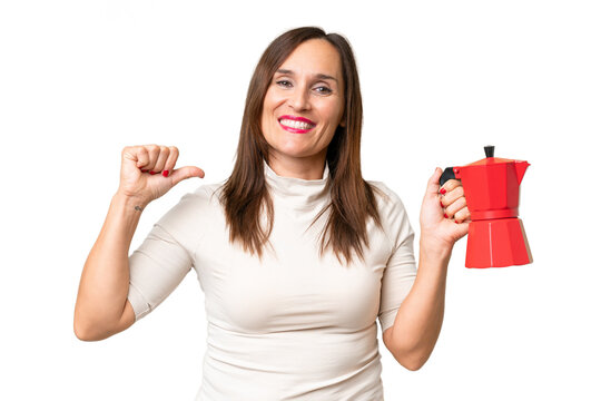Middle-aged caucasian woman holding coffee pot over isolated background proud and self-satisfied