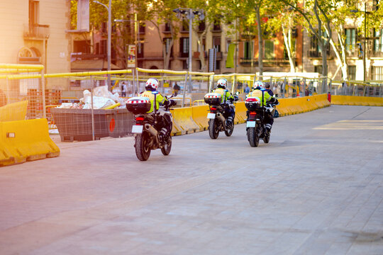 Three Police Officers on Motorcycles Patrolling Near City Construction Site