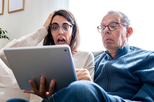 Father and daughter reacting with shock to news on tablet
