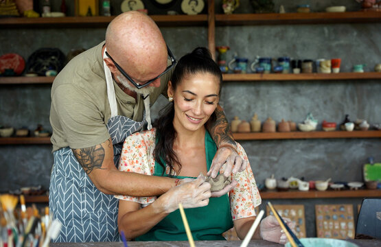A happy couple makes ceramic plates in a workshop