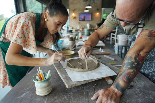 A happy couple makes ceramic plates in a workshop