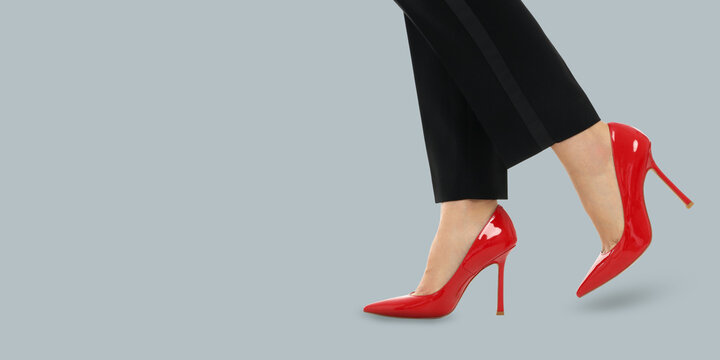 A woman walks in stylish red high heels, showcasing elegance