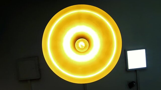 Bright yellow-orange ceiling light fixture glowing intensely, creating a warm, energetic ambiance