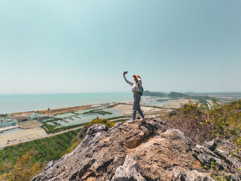 Enthusiastic adventurer stands victorious on high summit